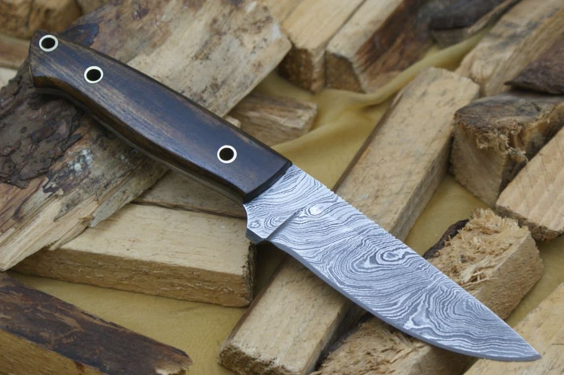 Handmade Damascus hunting knife. Wood handle. Razor sharp. Solid quality hunter. Comes with a sheath.